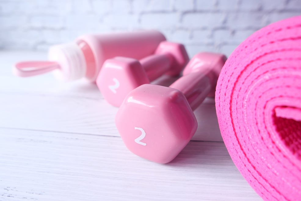 Pink Color Dumbbell, Exercise Mat and Water Bottle on White Background